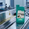 Motorex Supergliss 100 K Ölflasche, daneben goldener Schmiermittel-Tropfen auf einer silbernen Metallschiene.