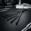 Schwarze DT Swiss Revolite Straightpull Nirosta Speichen (2.0) auf dunkler Werkbank mit Werkzeug.