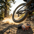 Maxxis Freeride/DH 26" Fahrradschlauch (verpackt & offen) vor Mountainbike, Staub aufwirbelnd.
