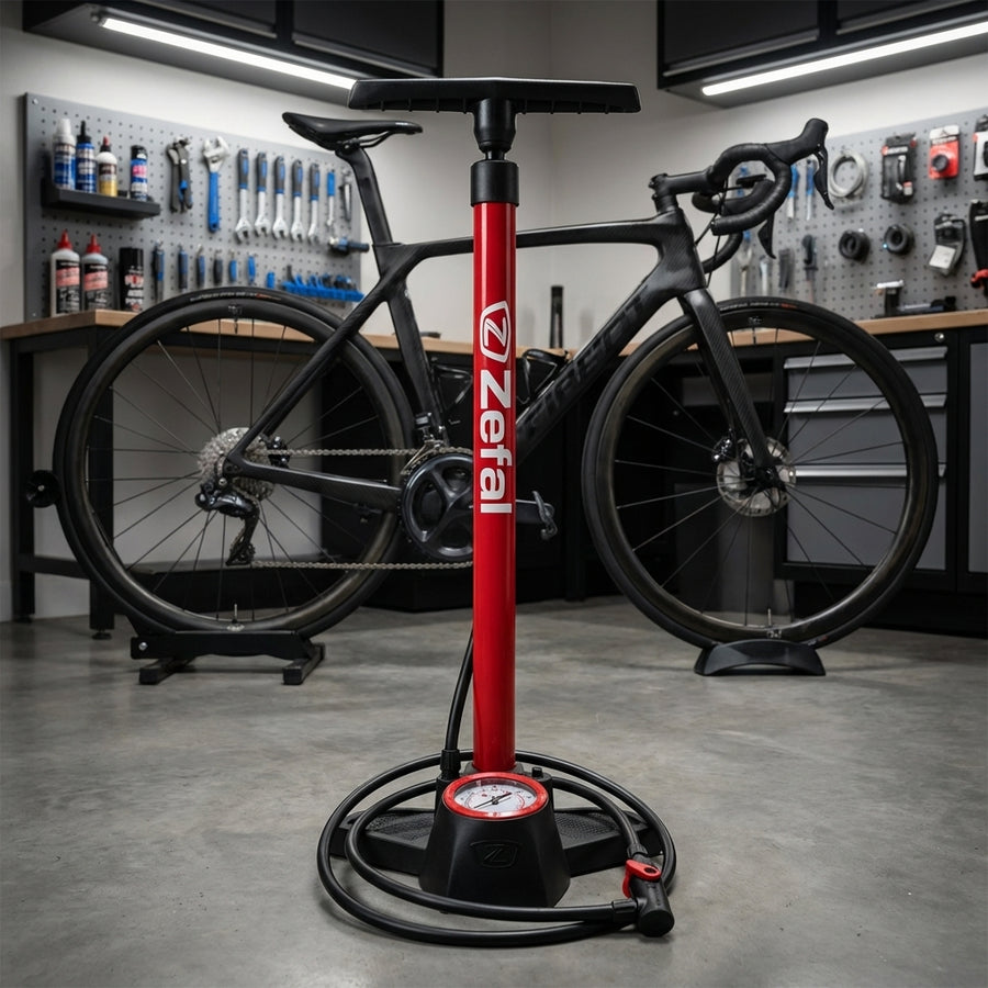 Rote Zefal Standpumpe Profil Max FP30 mit Manometer für AV SV DV Ventile, vor einem schwarzen Rennrad.