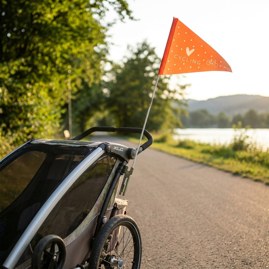 XLC Sicherheitswimpel orange 'Love cycling' am Fahrradanhänger auf Radweg.