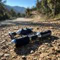 XLC CO2-Patronenpumpe PU-M03 mit 16g Ersatzpatrone auf einem Schotterweg vor Bergkulisse.