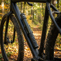 Crankbrothers Klic HV Handpumpe Midnight Edition schwarz mit Rahmenhalter am Fahrradrahmen im Herbstwald.