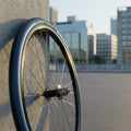 Michelin Dynamic Sport Draht Drahtreifen 28 Zoll 700x23 23-622 am Fahrradrad, an Betonwand, Stadtkulisse.