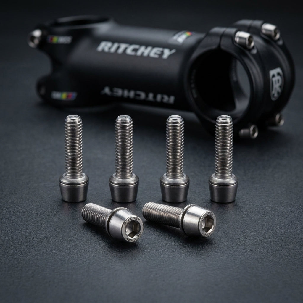 6 silberne Ritchey WCS-Comp 4Axis Vorbauschrauben aus Edelstahl, korrosionsbeständig, mit Vorbau im Hintergrund.