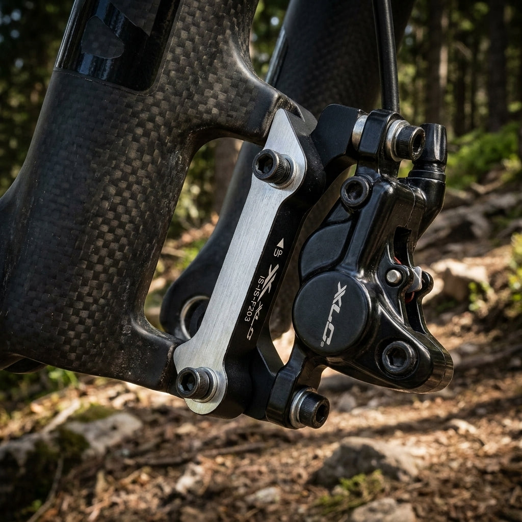 XLC Scheibenbremsadapter IS-IS-F203 montiert an Carbon-Fahrradgabel mit schwarzem Bremssattel, Detailaufnahme.