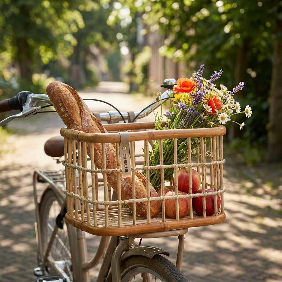 Basil Green Life Rattan Fahrradkorb natur braun mit Baguette, Blumen und Äpfeln am Fahrrad.