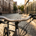 Ergotec Trekking Lenkerbügel Alu-Look 47° am Fahrrad auf Kopfsteinpflasterstraße in der Stadt bei Sonnenschein.