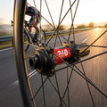 Leichte DT Swiss 240 EXP Highend Vorderradnabe schwarz, Speichen, Radfahrer auf Straße bei Sonnenuntergang.