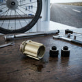 Novatec Freilaufkörper Campagnolo B1 9-11-fach auf Holztisch mit Fahrradlaufrad und Werkzeugen.