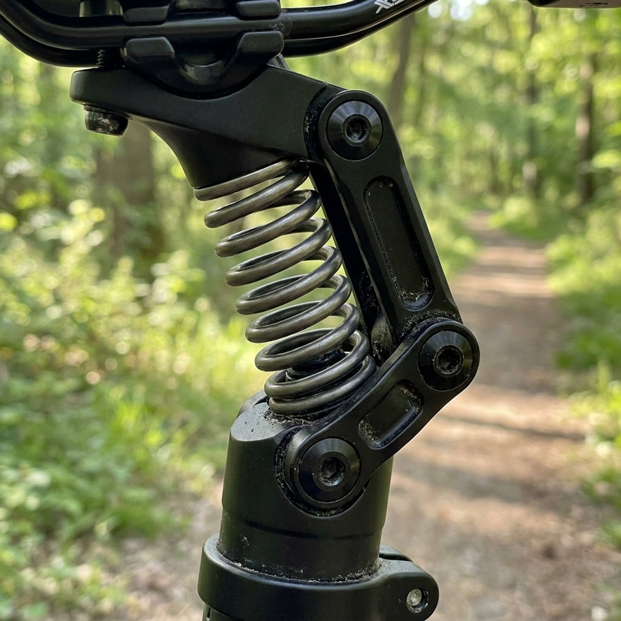 XLC SP-S11 Federelement medium (70-95kg) schwarz am Fahrrad auf Waldweg.
