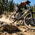 Mountainbiker in Aktion mit RockShox Feder Vivid/Kage 600LB auf felsigem Trail.
