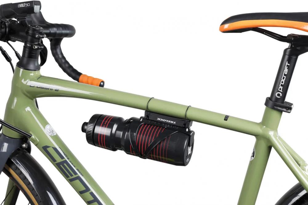 TRELOCK ADD IT universelle Fahrradhalterung mit Trinkflasche auf grünem Fahrrad-Oberrohr montiert.