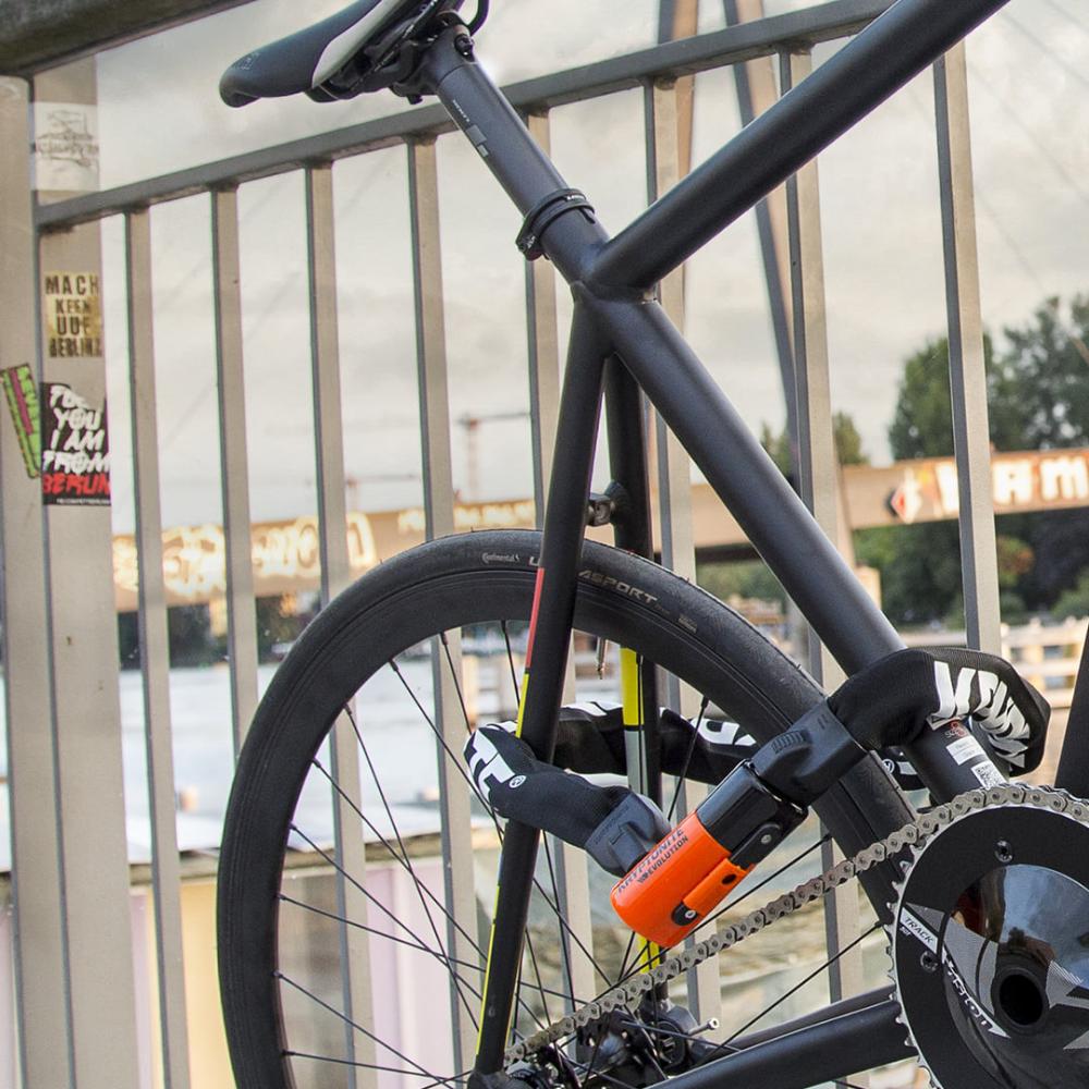 KRYPTONITE Evolution 1090 Kettenschloss (90cm) sichert schwarzes Fahrrad hochsicher an Geländer.
