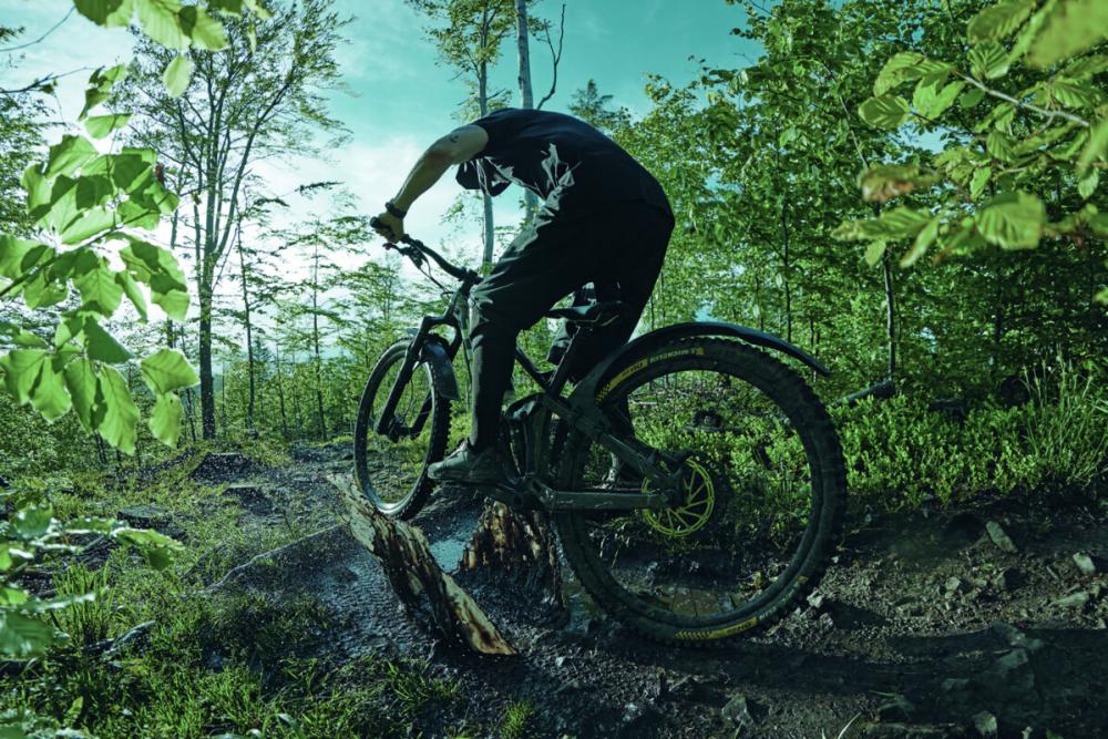 SKS Mudrocker Rear Schutzblech am Mountainbike in Aktion auf schlammigem Trail, zeigt optimalen Spritzschutz.