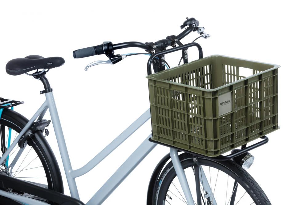 Grüne Basil Fahrradkiste M (29,5L) aus nachhaltigem Kunststoff am hellgrauen Fahrrad. Ideal für Damen- & Herrenräder.