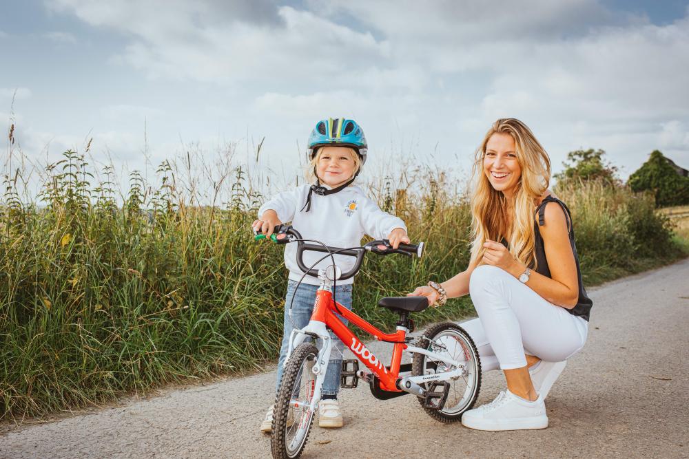 Schwalbe Little Joe 16 Zoll Kinderfahrradreifen an rotem Rad, Kind und lächelnde Frau auf Weg.