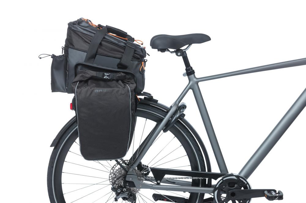 Basil Gepäckträgertasche Miles Tarpaulin XL Pro MIK 2.0 in schwarz/orange am grauen Fahrradheck mit Seitenpacktaschen.