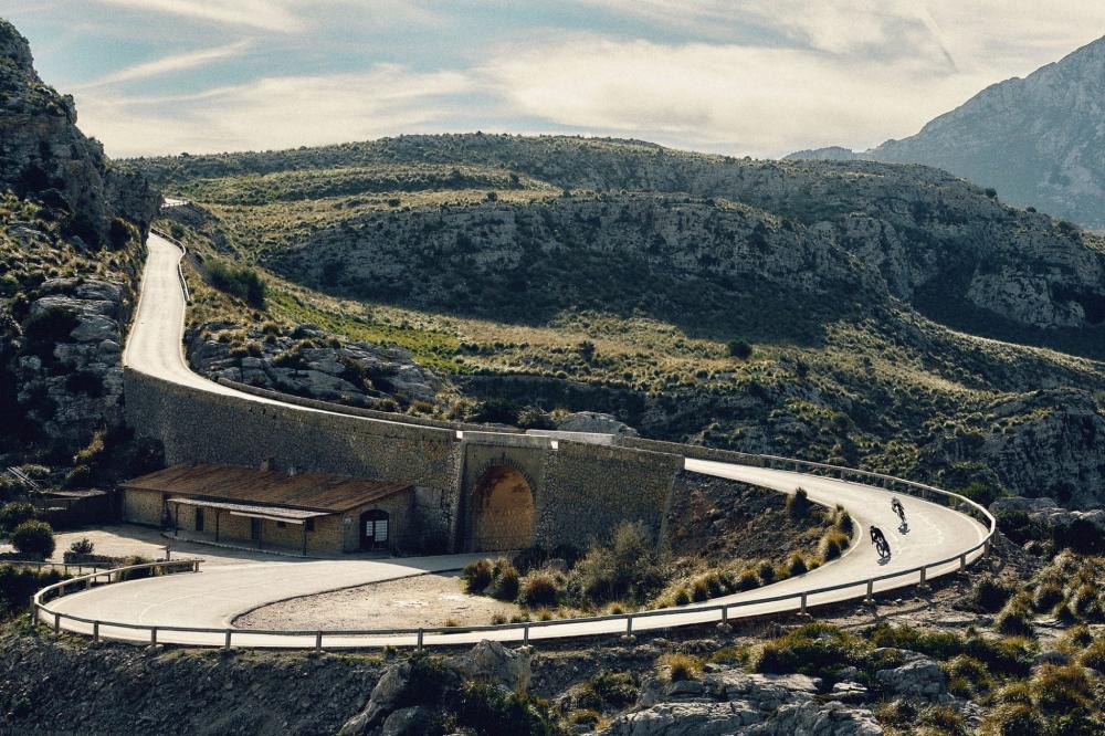 Continental Grand Prix 5000 S TR Tubeless-Ready Rennradreifen im Einsatz auf kurviger Bergstraße mit Radfahrern.