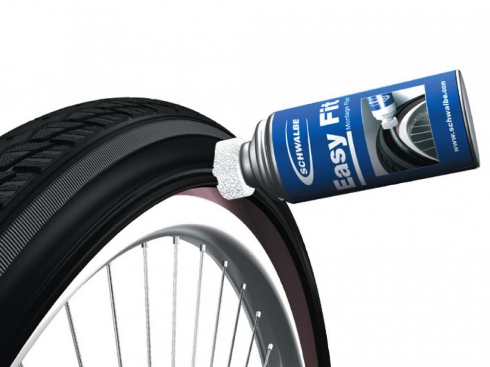 Schwalbe Easy Fit Montagefluid wird auf einen Fahrradreifen auf einer Felge aufgetragen, ideal für 20-Zoll-Reifen.