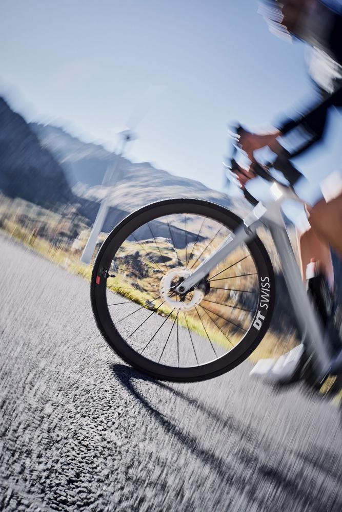 Ultraleichtes schwarzes DT Swiss ARC 1100 Dicut Disc Aero-Carbonlaufrad am Rennrad in Fahrt.