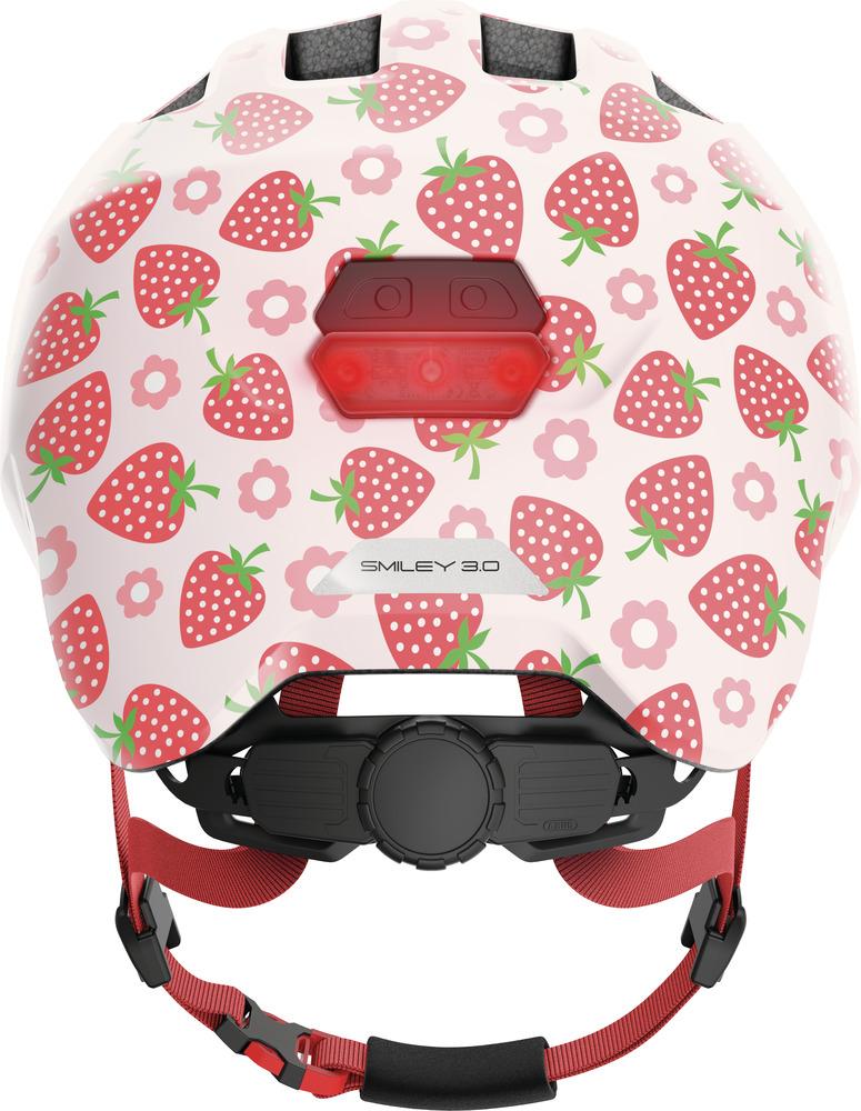 Abus Kinderhelm Smiley 3.0 LED rose strawberry M 50-55cm, weiß mit Erdbeeren und rotem Rücklicht.