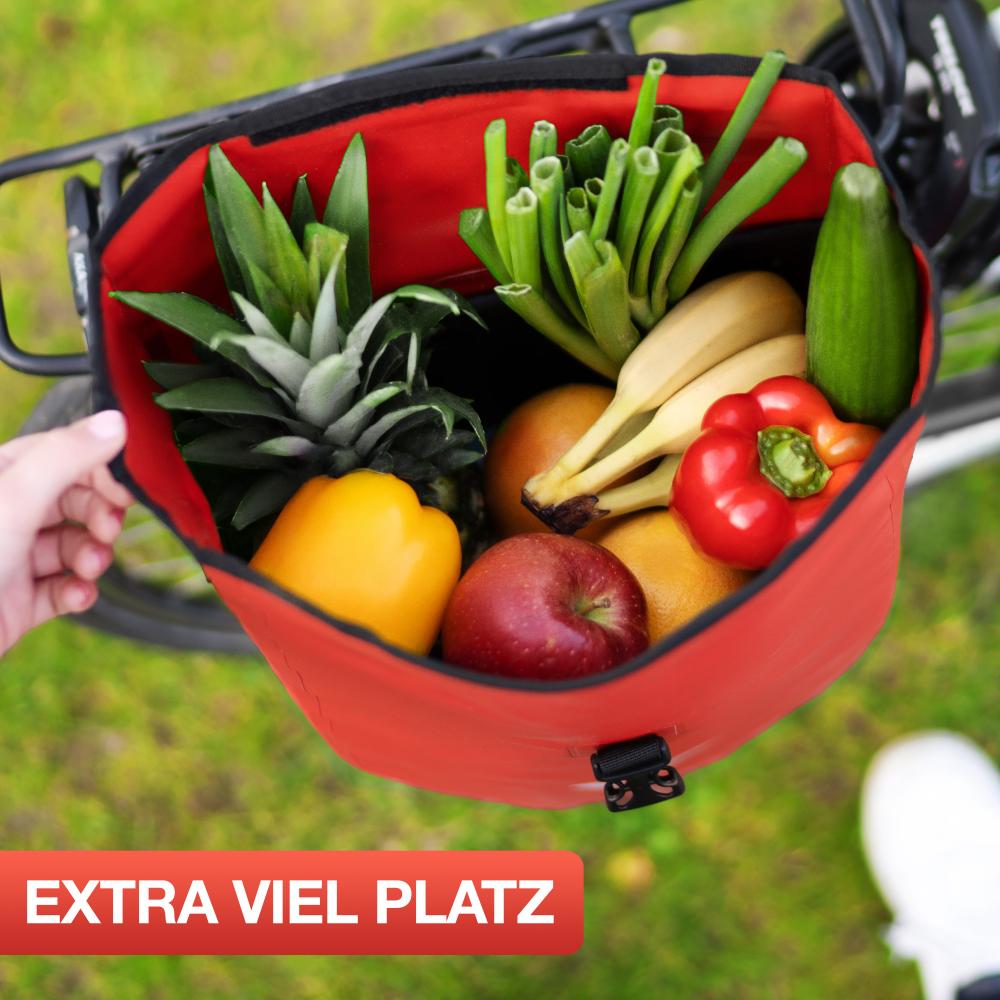Rote Valkental Gepäckträgertasche 20L am Fahrrad, prall gefüllt mit frischem Obst und Gemüse.