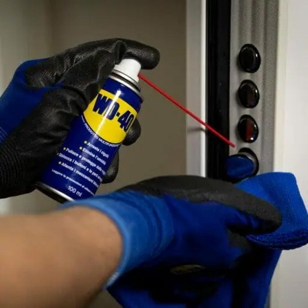 WD-40 Classic 100 ml Multifunktionsöl wird zur Schmierung und zum Rostschutz auf ein Metallteil gesprüht.