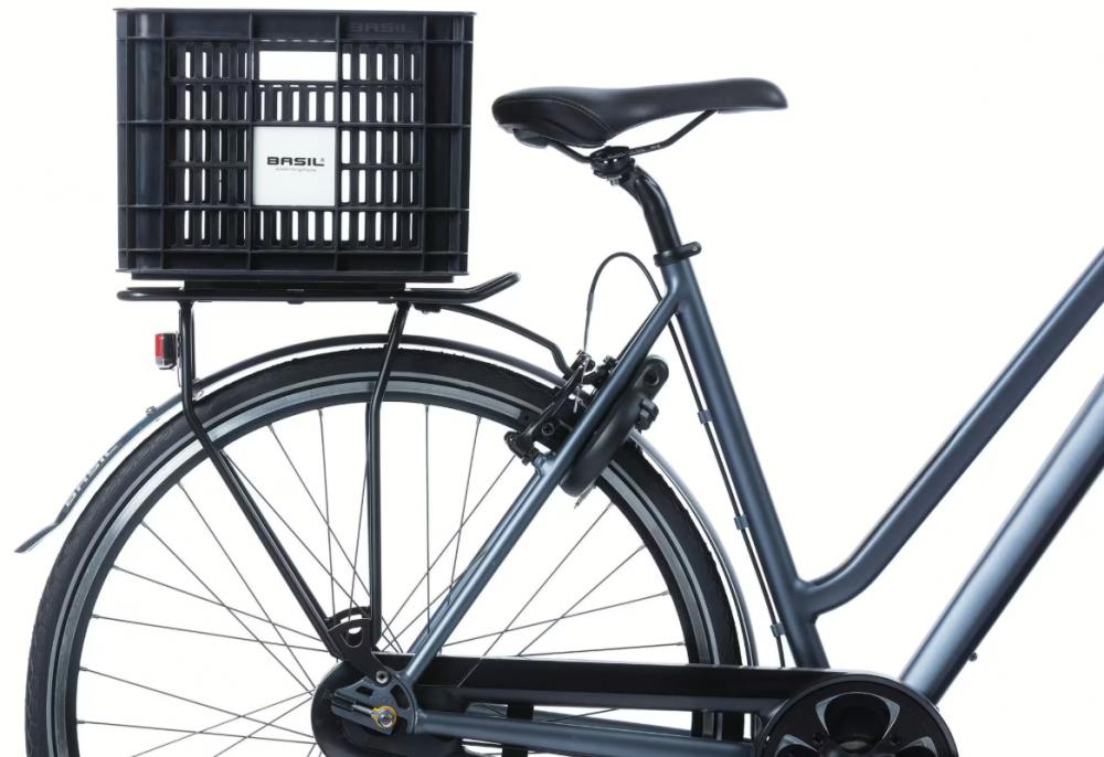 BASIL H.R.-Korb Fahrradkiste MIK 2.0 aus recyceltem Kunststoff (29,5L) auf dem Gepäckträger eines Fahrrads montiert.