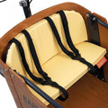 Babboe Lastenrad Kissenset Mellow Yellow für Go, gelbe Polster mit schwarzen Sicherheitsgurten im Holzkasten.