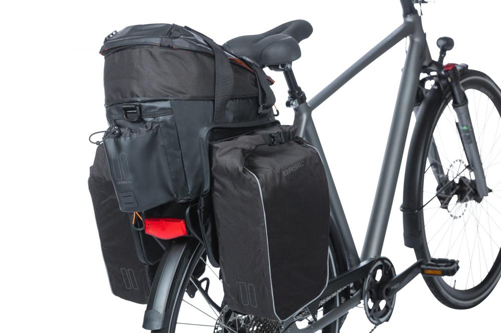 Basil Miles Tarpaulin XL Pro Gepäckträgertasche schwarz/orange MIK 2.0 am schwarzen Fahrrad mit Seitentaschen.