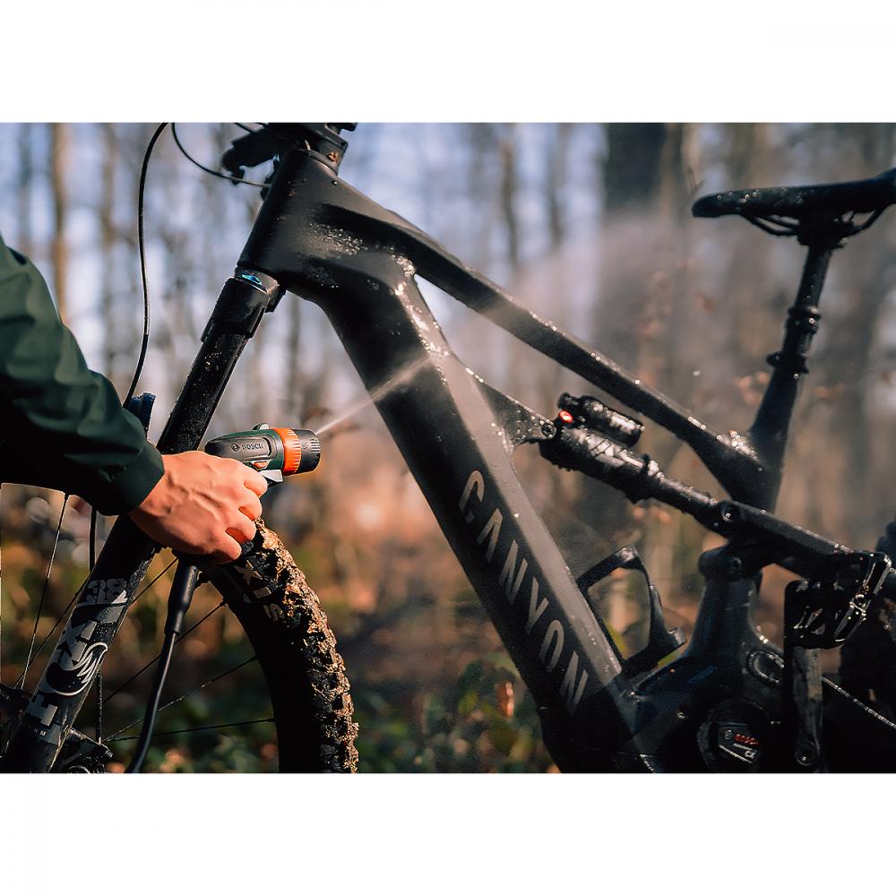 Bosch Fontus 18V-6 Akku Bike Cleaner reinigt ein schlammiges Canyon Mountainbike im Wald.
