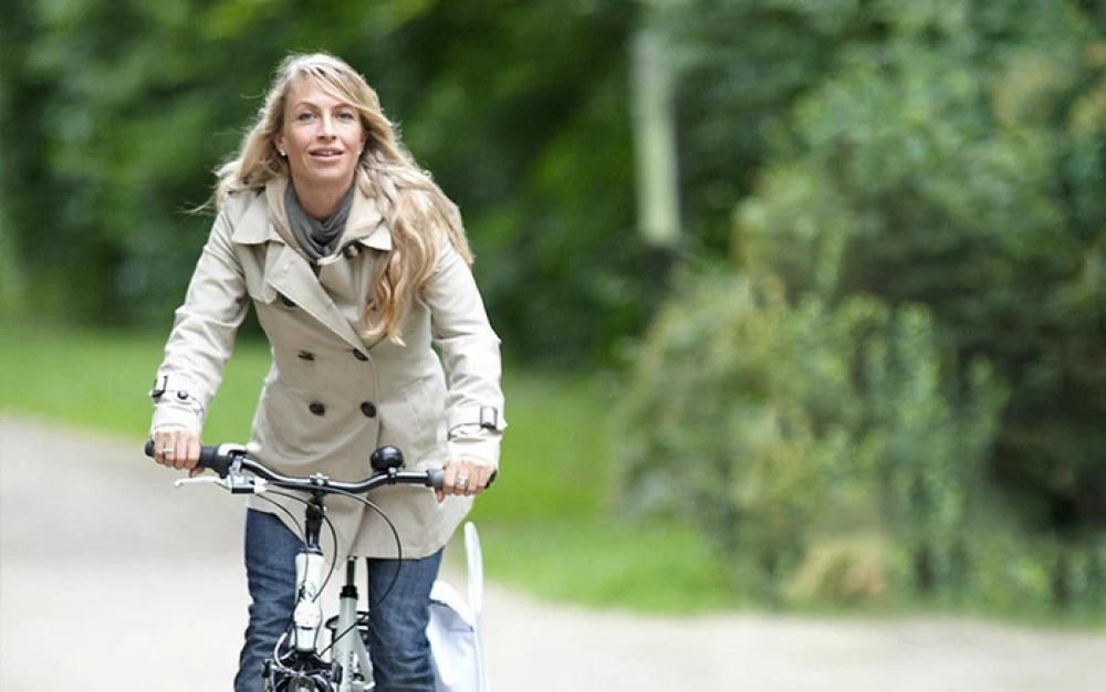 Frau fährt Fahrrad mit Selle Royal Lookin Relaxed Stracciatella Sattel für maximalen Sitzkomfort und entspanntes Fahren.