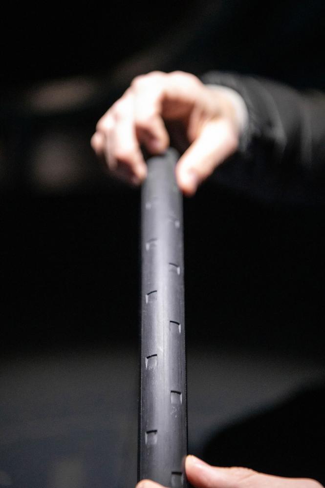 Hand hält schwarzes DT Swiss ERC 1400 Dicut Fahrradreifenprofil, aerodynamisches Carbon-Vorderrad.