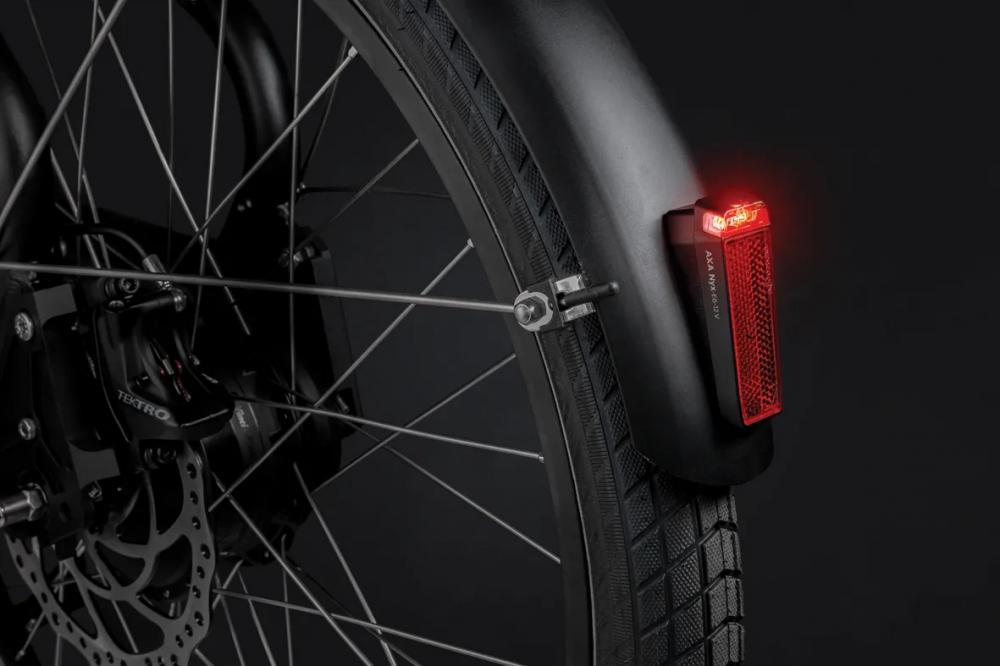 AXA NYX E-Bike Rücklicht 6-12V StVZO, rot leuchtend, am schwarzen Hinterrad mit Schutzblech.