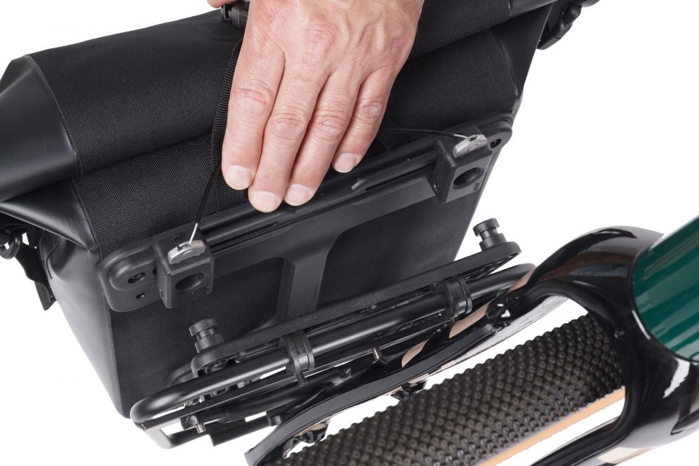 Hand befestigt schwarze Basil Navigator Waterproof Einzelpacktasche mit MIK Studs am Fahrrad-Gepäckträger.