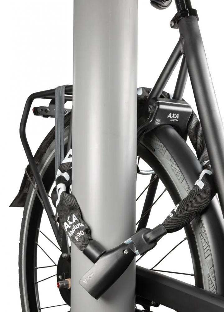 Robustes AXA Kettenschloss Absolute 8-90 (90 cm) sichert ein Fahrrad an einem Poller. Mit Click-In-Komfort.