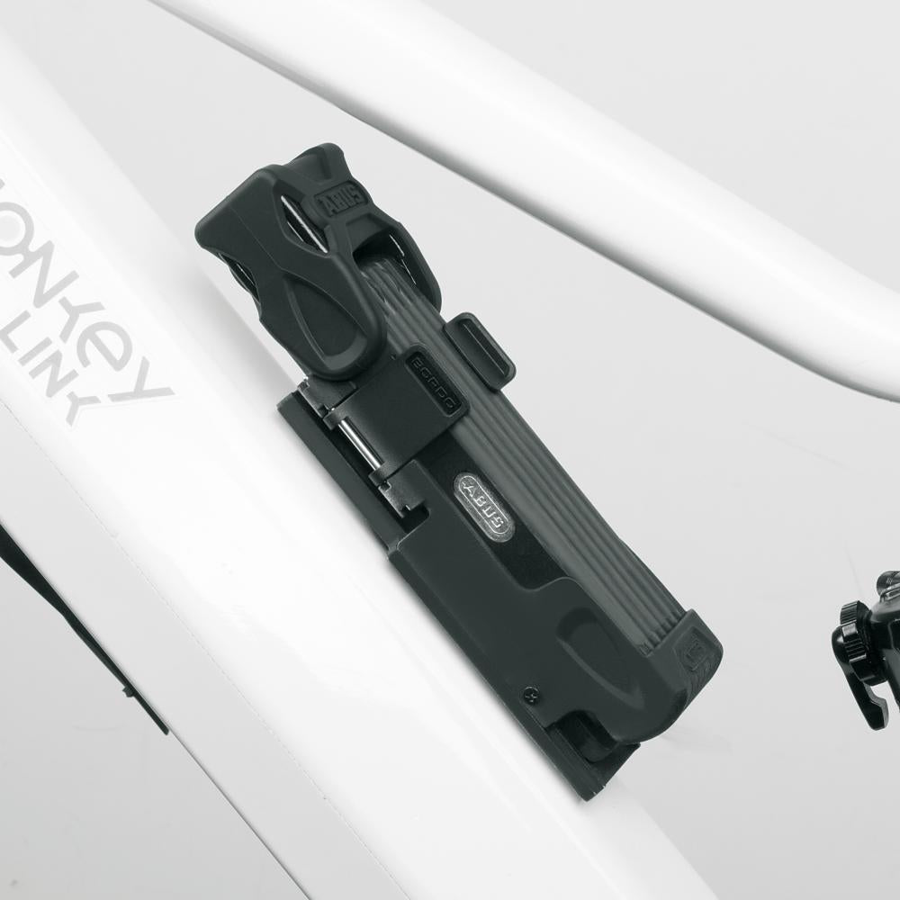 ABUS SH FL-Bordo Schloss-Halter schwarz für Fidlock Twist/MonkeyLink am weißen Fahrradrahmen, magnetisch befestigt.