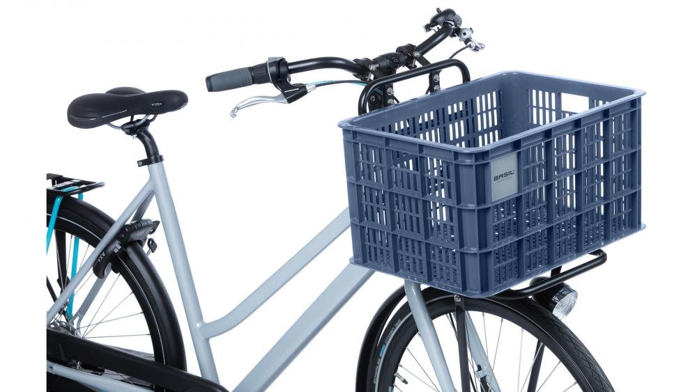 Fahrrad mit Basil Crate L Bluestone 40L Transportkorb aus Kunststoff auf dem vorderen Gepäckträger.