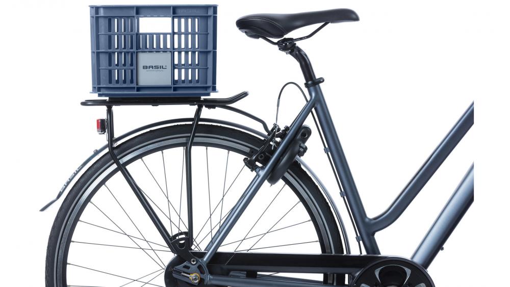 Basil Transportkorb Crate S Bluestone 17L auf dem Gepäckträger eines dunkelgrauen Fahrrads.