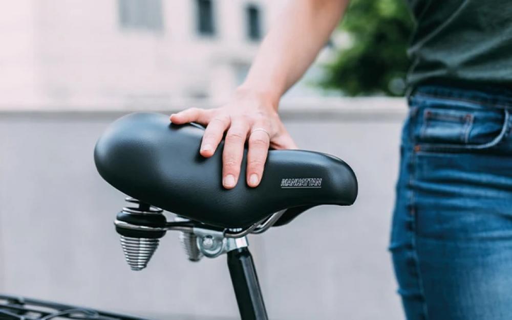 Selle Royal Manhattan Premium Fahrradsattel schwarz relaxed mit Federung, eine Hand liegt darauf.