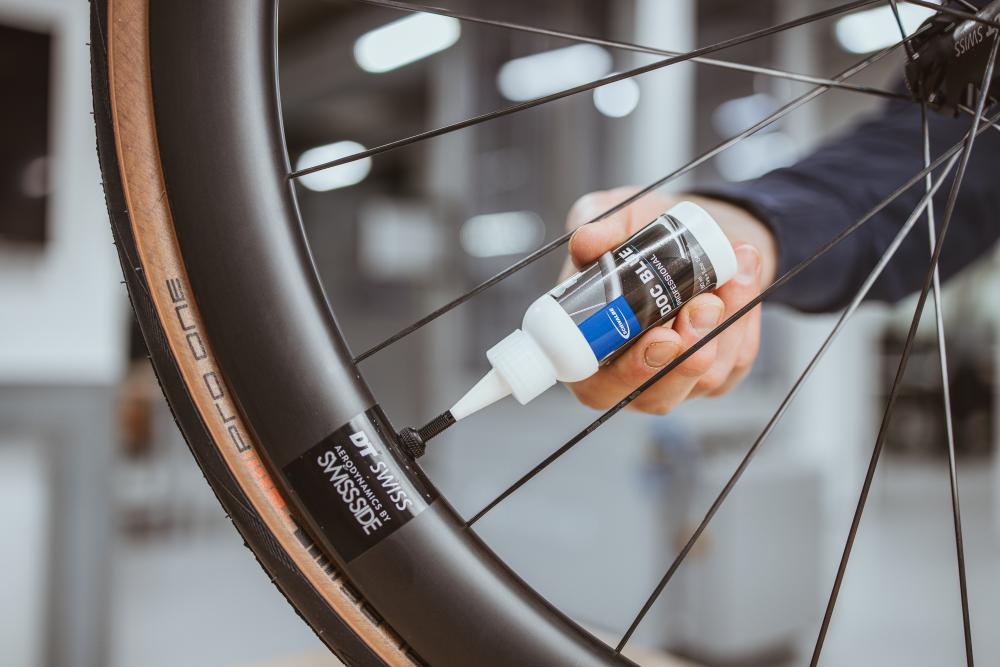 Schwalbe Doc Blue 60 ml Dichtmittel Sealant TLR wird zur Pannenvorsorge in ein DT Swiss Fahrradventil gefüllt.