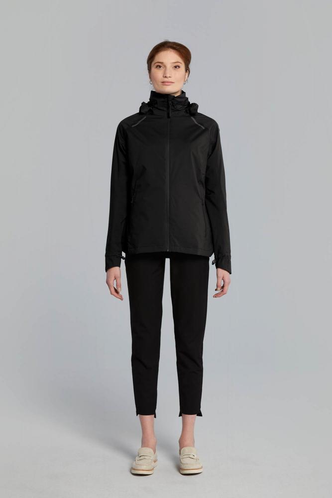 Frau trägt schwarze Basil Skane Damen Regenjacke, wasserdicht, atmungsaktiv, tailliert, reflektierend.