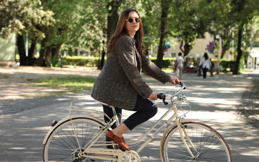 Frau fährt Rad mit Selle Royal Drifter Plus Relaxed braunem City-Komfortsattel mit doppelten Federn im Park.